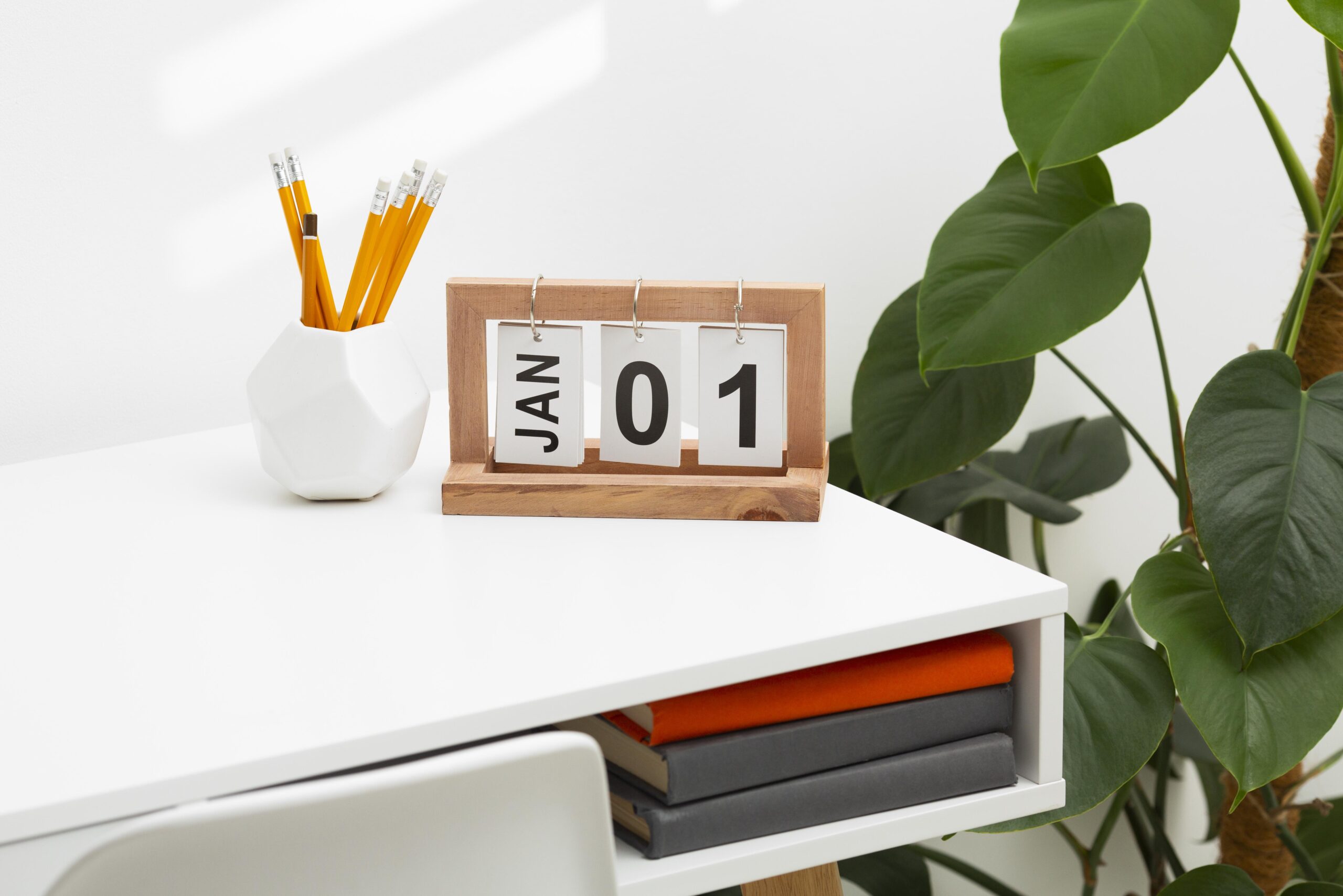 A calendar on a desk with a plant and desk. How to Manage Multiple Calendars